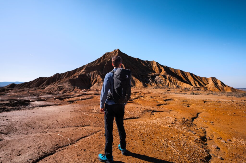 Homme debout de dos dans le désert avec le sac à dos Hike de NEO